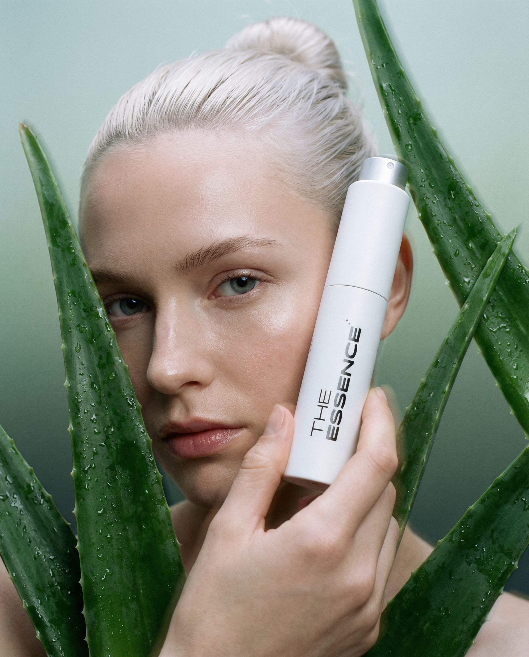 Held next to face by 25 year old danish woman with slicked platinum bun  bare lashes  and translucent skin finish